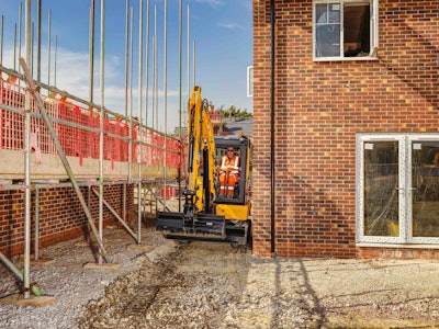 JCB 35Z electric compact excavator in narrow space between building and building under construction